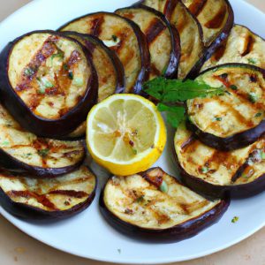 A plate of grilled eggplant slices with fresh herbs, spices and lemon wedges.