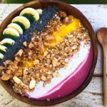 A colorful smoothie bowl filled with fresh fruit, yogurt, and granola
