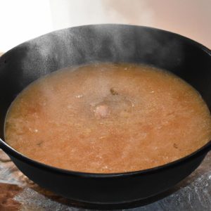 A large cast iron skillet with a steaming bowl of soup in the center.