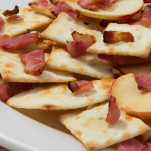 Close-up shot of a plate of the finished crackers with the bacon and apple pieces visible