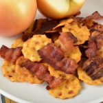 A close up image of a plate of golden and smoky apple bacon crackers