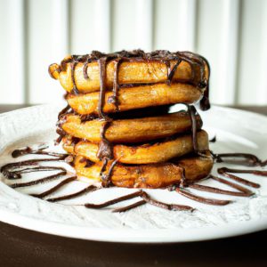 A stack of three fluffy Mexican Chocolate Churro Pancakes with a drizzle of chocolate syrup on a white plate.