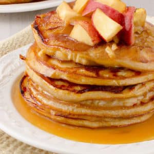 A stack of freshly made Apple Pie Pancakes with a delicious caramelized apple topping.